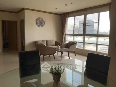 Spacious living room with large windows and city view, featuring modern furniture and elegant decor.