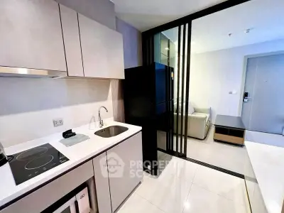 Modern kitchen with sleek design and open layout leading to living area