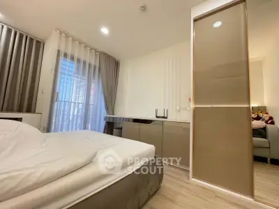 Modern bedroom with sleek design, featuring a cozy bed, stylish wardrobe, and natural light from large windows.
