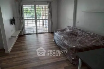 Spacious living room with large window and modern flooring, perfect for cozy gatherings.