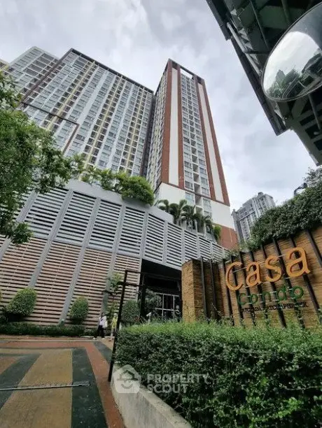 Modern high-rise condo with lush greenery and stylish entrance
