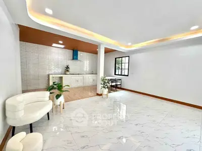 Spacious modern living room with open kitchen and elegant lighting.