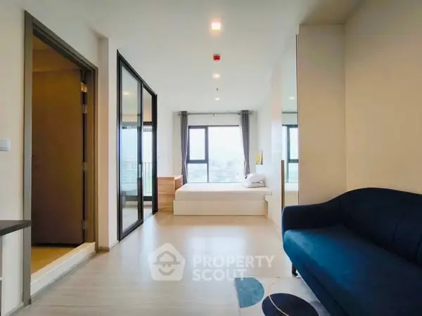Modern open-plan living space with bedroom and large windows