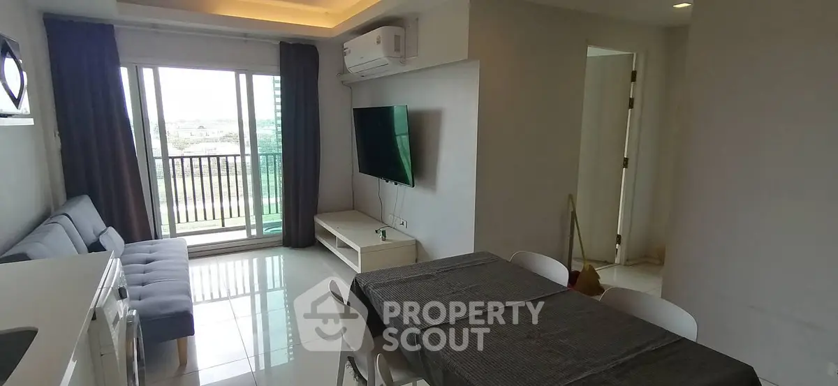 Modern living room with balcony view, featuring sleek furniture and natural light.