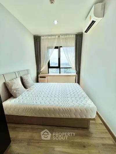 Modern bedroom with city view, featuring a cozy bed and air conditioning.