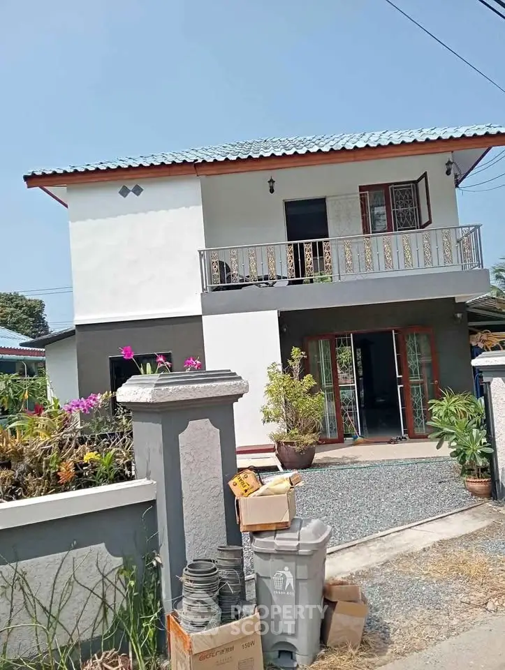 Charming two-story house with balcony and garden, perfect for family living.