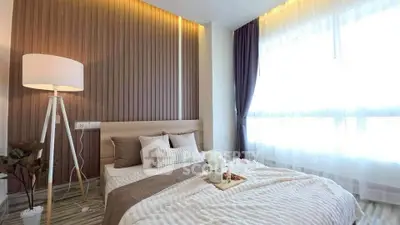 Elegant bedroom with modern decor and large window offering natural light