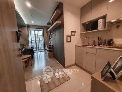 Modern open-plan living room and kitchen with stylish decor and city view balcony.