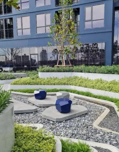 Modern urban garden with unique seating and lush greenery in a residential complex