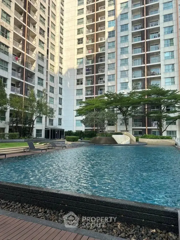 Luxurious condominium with a stunning pool and lush greenery, perfect for relaxation and leisure.