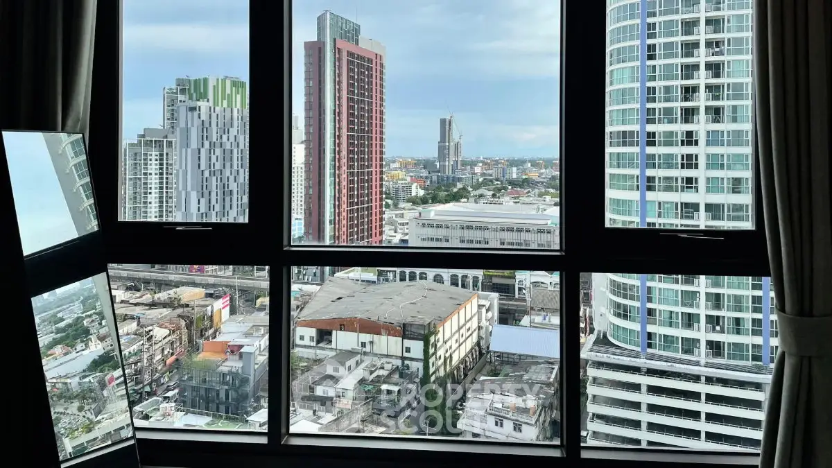 Stunning cityscape view from high-rise apartment window showcasing urban skyline.