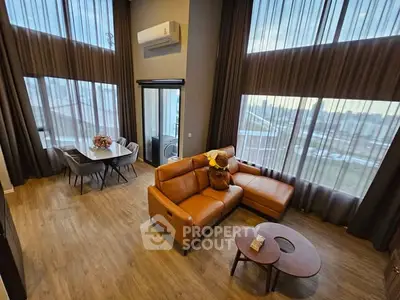 Spacious modern living room with high ceilings and large windows offering a stunning view.