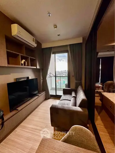 Modern living room with balcony view, featuring sleek furniture and stylish decor in a cozy apartment setting.