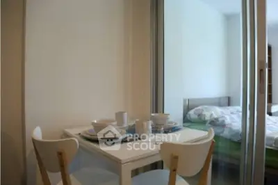 Cozy dining area with modern table and chairs next to a bedroom, perfect for compact living spaces.