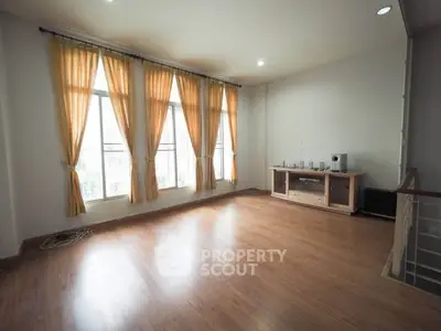 Spacious living room with large windows and wooden flooring