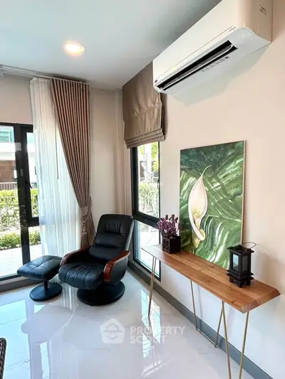 Modern living room with sleek furniture and large windows offering natural light.