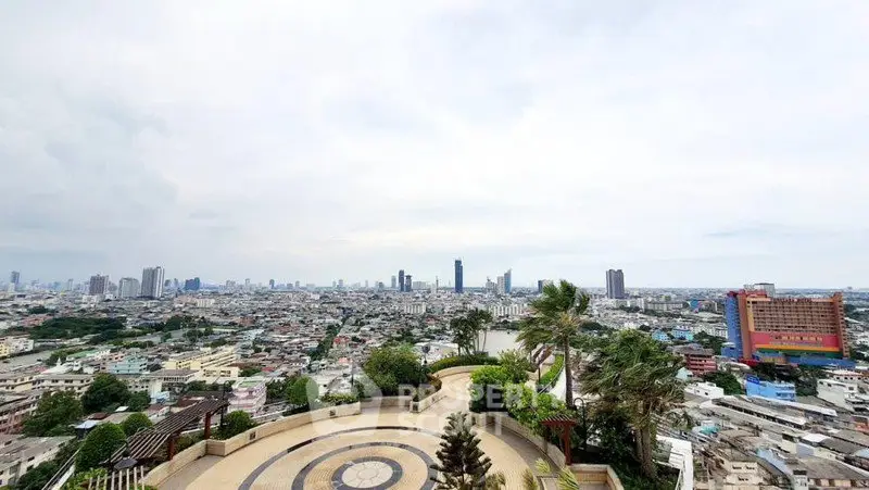 Stunning panoramic city view from a high-rise building with lush greenery and skyline.