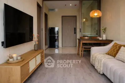 Modern living room with stylish decor and cozy ambiance, featuring a wall-mounted TV and elegant lighting.