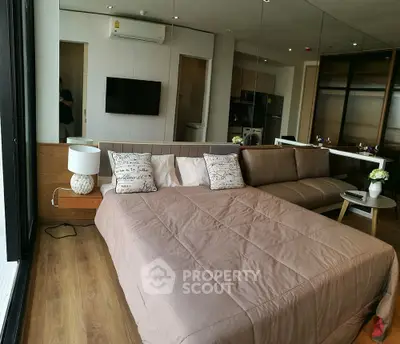 Modern studio apartment with cozy bed and stylish decor, featuring a sleek open layout and contemporary furnishings.