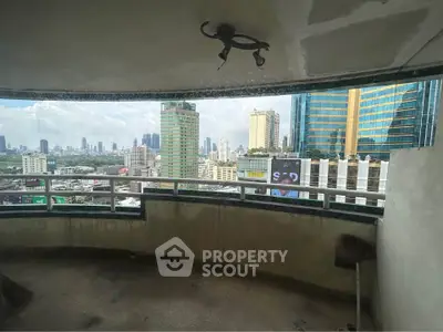 Spacious balcony with panoramic city views in high-rise building.