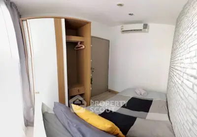 Cozy bedroom with modern decor and air conditioning, featuring a stylish wardrobe and comfortable bedding.