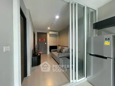 Modern living room with sliding glass doors and sleek gray furniture in a stylish apartment.