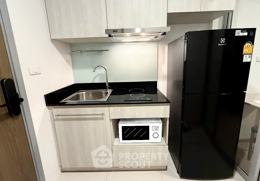 Modern compact kitchen with sleek black appliances and minimalist design