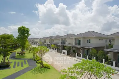 Beautiful suburban neighborhood with modern houses and lush greenery under a bright blue sky.