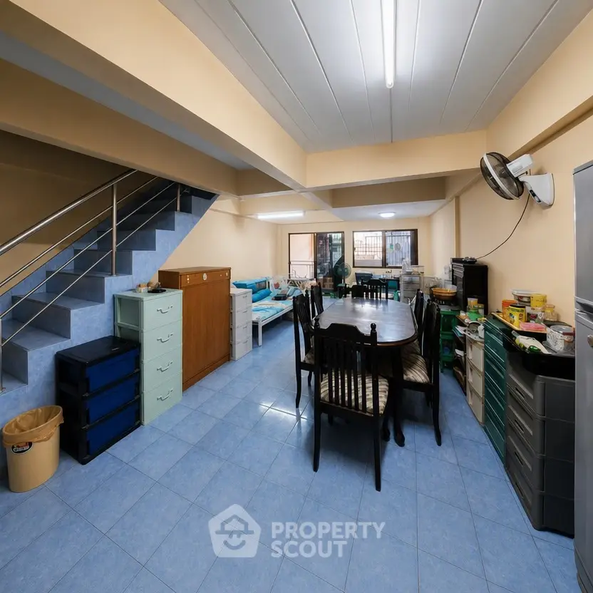 Spacious open-plan living area with dining set and modern staircase in a cozy home.