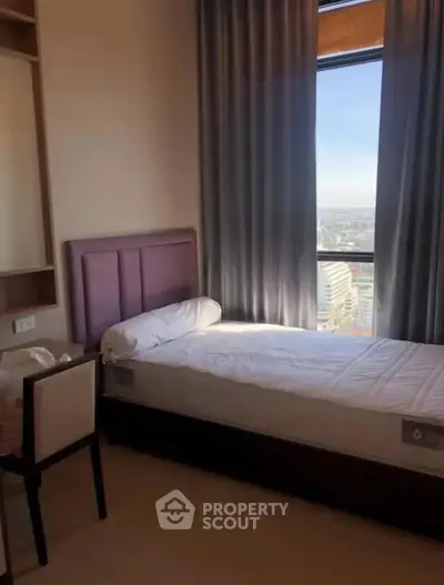 Cozy bedroom with single bed and city view from window