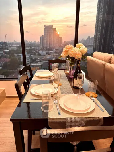 Elegant dining area with stunning city view at sunset, featuring a beautifully set table and cozy seating.