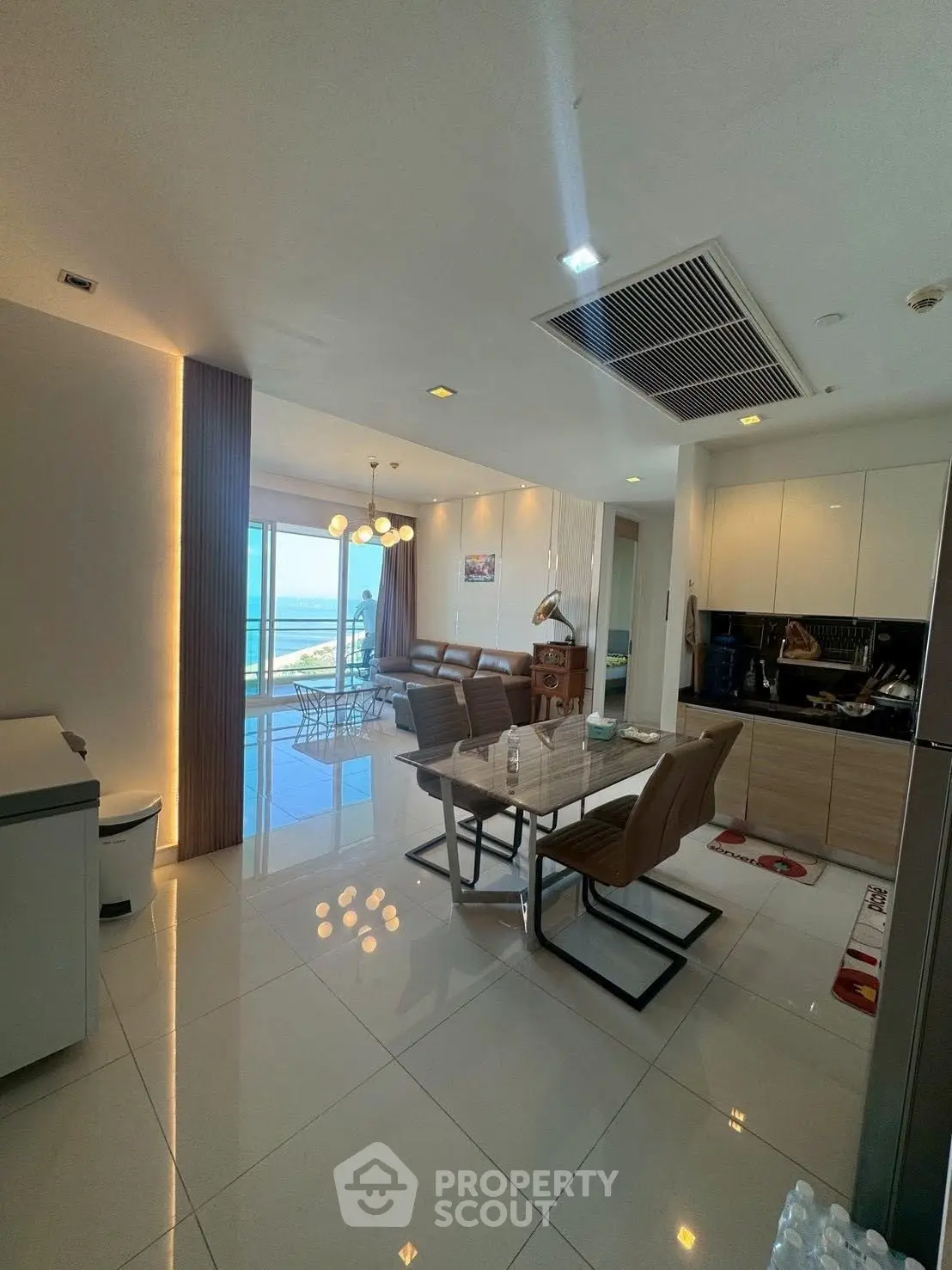 Luxurious open-plan living and dining area with stunning ocean view, modern furniture, and elegant lighting.