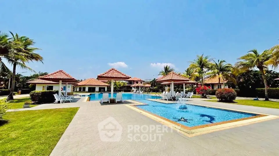 Luxurious resort-style pool area with palm trees and cabanas, perfect for relaxation and leisure.