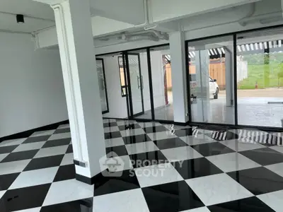 Spacious modern interior with checkered flooring and large glass doors
