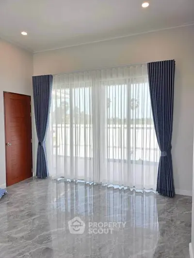 Spacious living room with elegant curtains and glossy marble flooring, perfect for modern living.