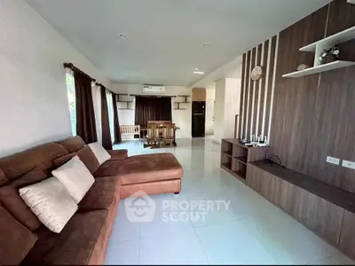Spacious living room with modern decor and open layout, featuring a cozy sectional sofa and dining area.