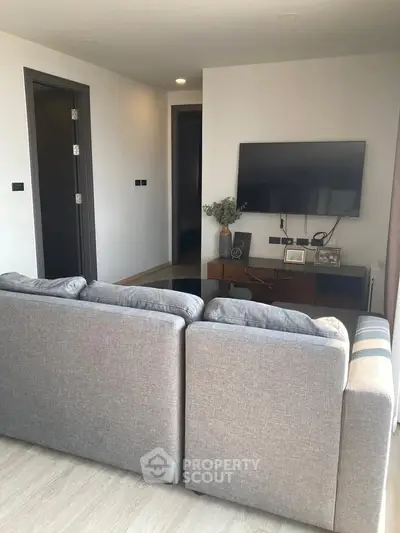Modern living room with sleek TV setup and cozy gray sofa