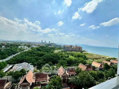 Stunning coastal view from high-rise overlooking lush greenery and city skyline.