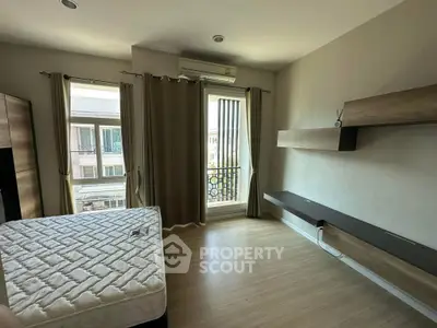 Spacious bedroom with large window and modern shelving in a stylish apartment.