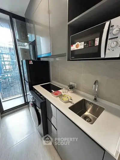 Modern kitchen with sleek appliances and balcony view