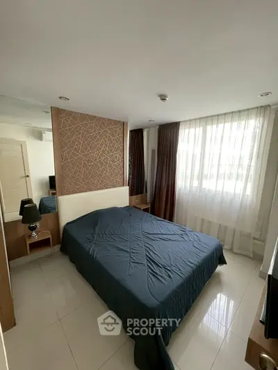 Modern bedroom with stylish decor and natural light, featuring a comfortable bed and elegant curtains.