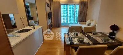 Modern open-plan living room with dining area and city view, featuring sleek furniture and wooden flooring.