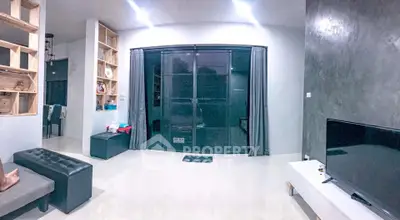 Spacious modern living room with sleek decor and large windows.