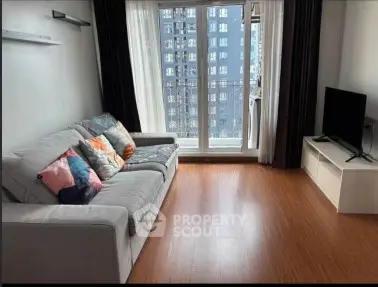 Modern living room with cozy sofa and large window offering city view.