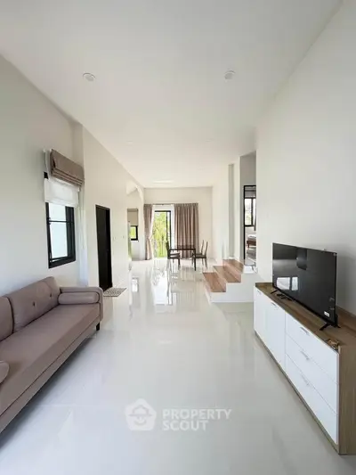 Spacious modern living room with sleek white tiles and stylish furniture, perfect for contemporary living.