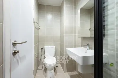 Modern minimalist bathroom with sleek fixtures and neutral tiles.