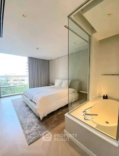 Luxurious bedroom with modern bathtub and large window offering scenic views.
