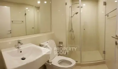 Modern bathroom with glass shower and sleek fixtures in a contemporary apartment.