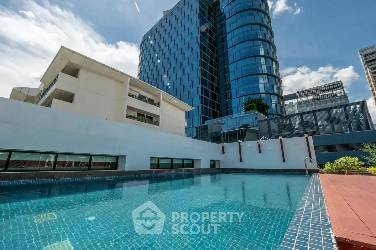 Luxurious high-rise building with a stunning outdoor pool and modern architecture.