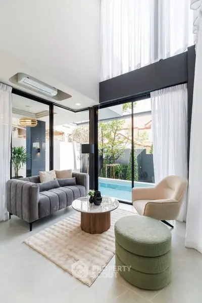 Luxurious modern living room with high ceilings and pool view